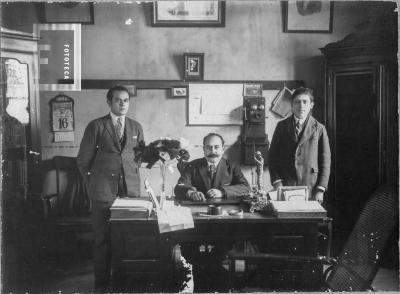 Tres hombres tras escritorio