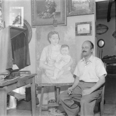 César C. Bustos (Pocholo) junto a cuadro de Anita y César Alberto, bebé