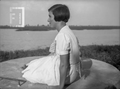 Dama sentada sobre instalaciones antiguas Aguas Corrientes, arroyo Yaguarón