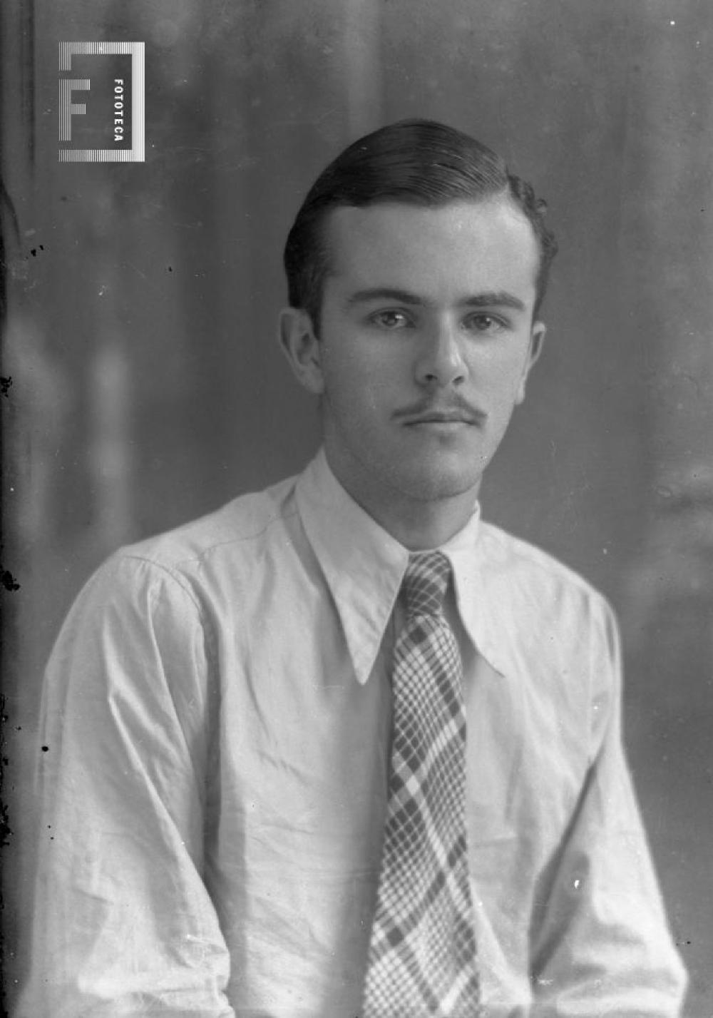 César Carlos Bustos (Pocholo) joven, de camisa y corbata
