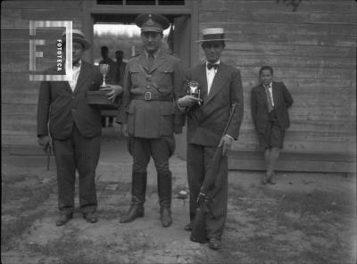 En Tiro Federal, 1934, militar en el centro y dos tiradores con trofeo