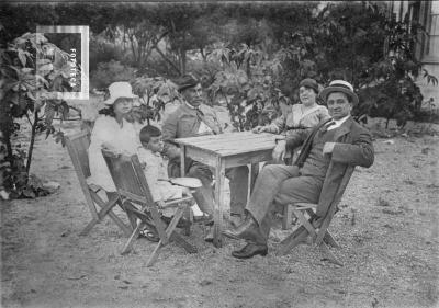 Pocholo, Margarita, Evaristo Paulina y Carlos L. alrededor mesa en jardín