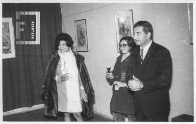 Duilio Cámpora y dos damas en sala exposición de Cora Zamora