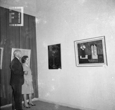 Exposición cuadros. Sr. Oscar Fulía y Sra. observando