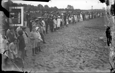 Gente en la playa, atrás tanque aguas corrientes