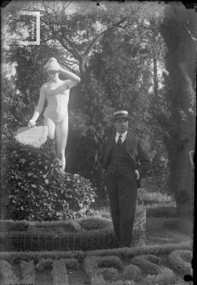 Carlos Bustos junto a estatua en los jardines de Palermo