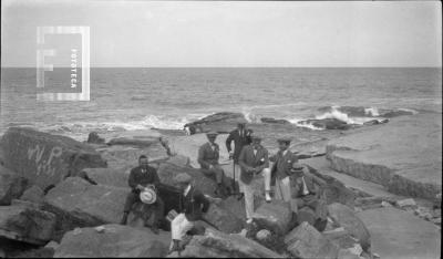 En Mar del Plata, grupo sentado en la costa